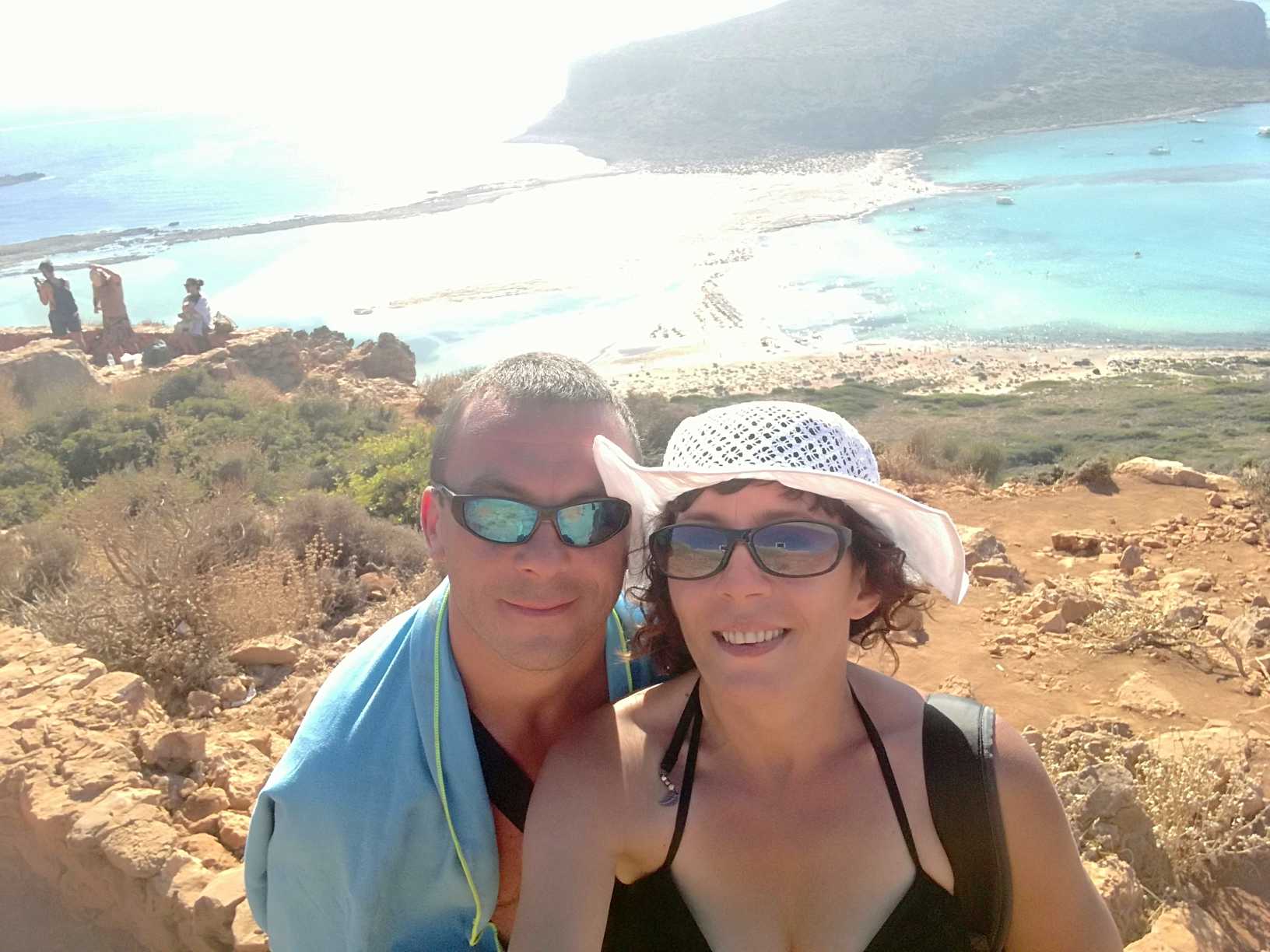 Szczęśliwa para na tle skalistej plaży i wody.